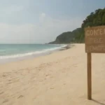 Una playa serena y despojada con señales ecológicas que promueven la conservación y las prácticas turísticas responsables.