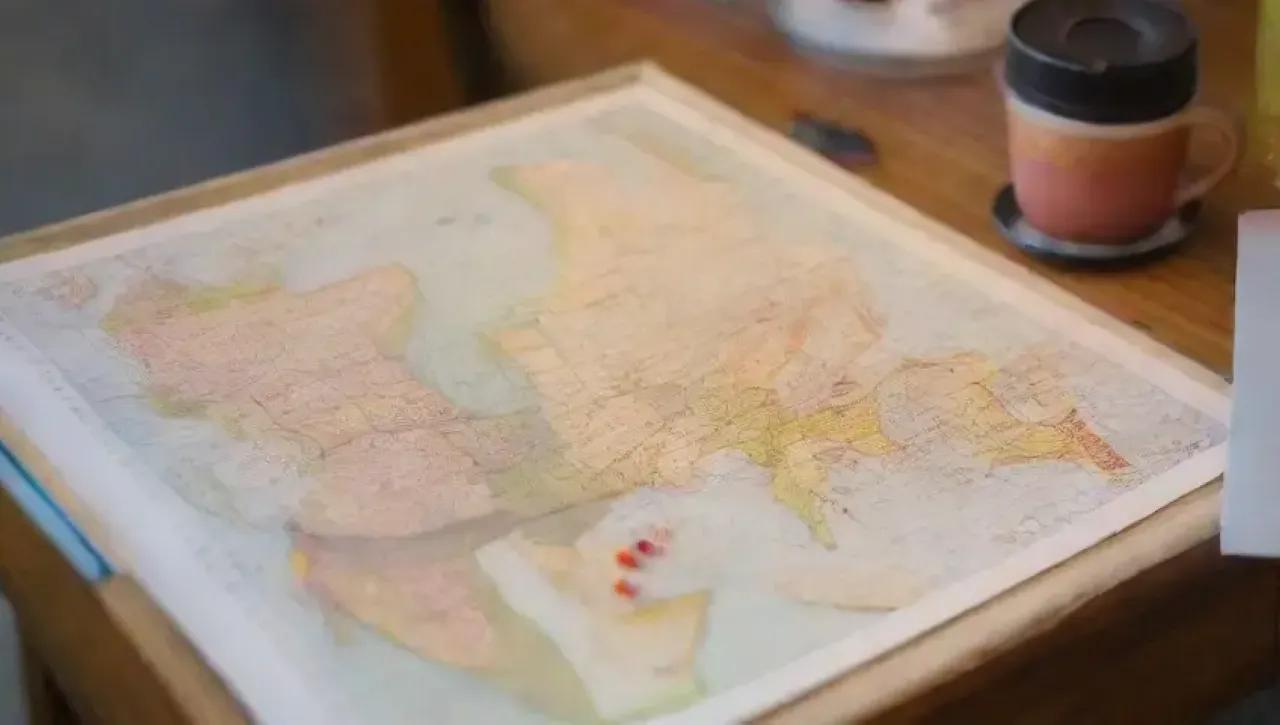 Una mesa llena de mapas, recuerdos de viaje y calidez hogareña
