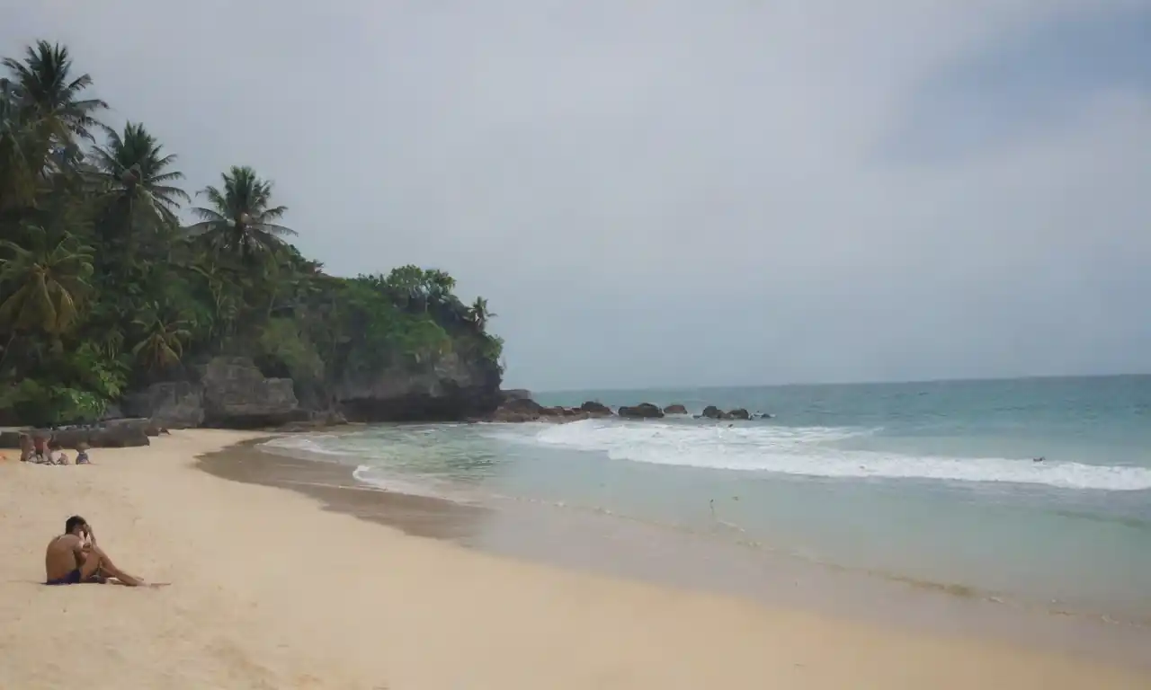 Una escena de playa serena en Bali, con elementos culturales vibrantes y turistas disfrutando de la relajación y las actividades.