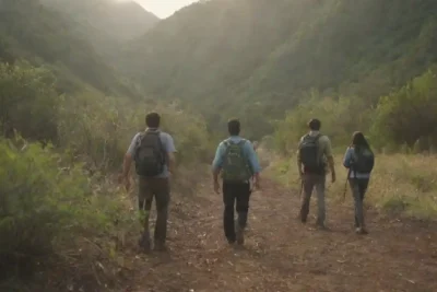 Grupo de personas explorando un sendero natural con información sobre conservación ambiental.