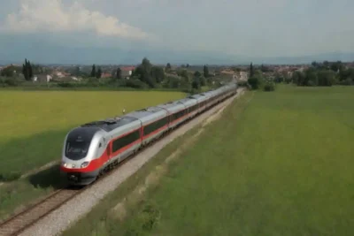 Tren que recorre pintorescos paisajes italianos hacia Venecia.