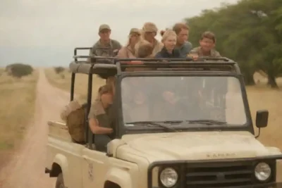 Un grupo de turistas en un vehículo safari observando la fauna