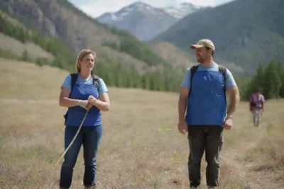 Grupo de voluntarios limpiando senderos en una montaña rodeada de naturaleza.