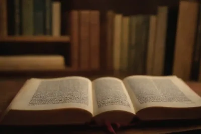 Libros abiertos rodeados de símbolos culturales como arte