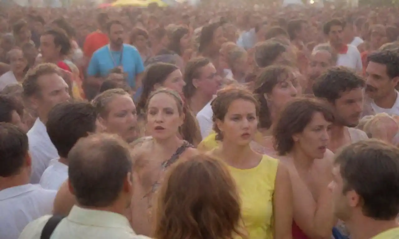 Multitud de personas vibrando y disfrutando de actuaciones en un colorido festival cultural al aire libre.