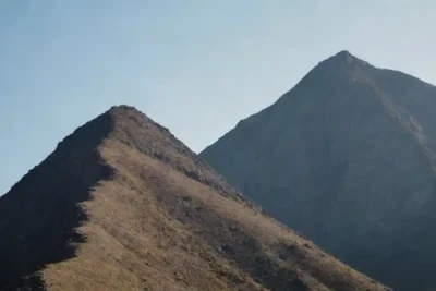 Comparación lado a lado de una montaña que se eleva sobre una colina suavemente inclinada.