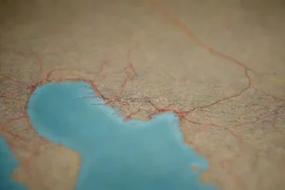 Persona ajustando su itinerario con un mapa y pronóstico del tiempo en un entorno natural.