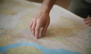 Viajero examinando un mapa con normativa ambiental y directrices etiquetadas.