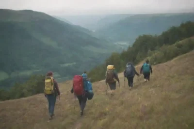 Un grupo de excursionistas que participan en actividades de conservación en medio de un paisaje escénico.