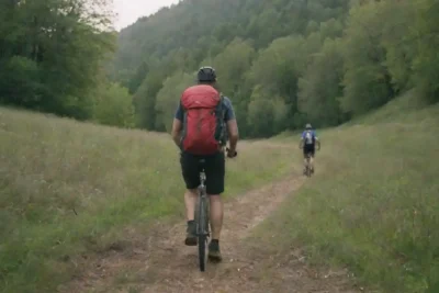 Los aventureros que exploran paisajes rurales pintorescos mientras hacen senderismo y ciclismo.