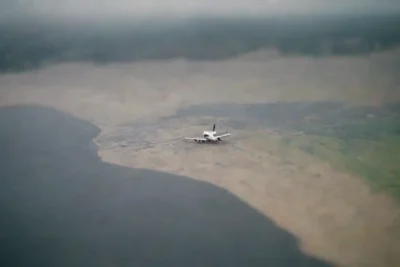 Pasajeros revisando un mapa y ajustando planos en el puerto mientras llueve.