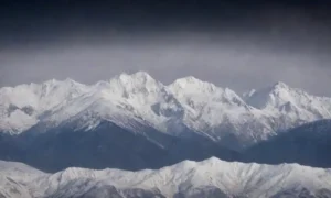 Montañas cubiertas de nieve con un mapa meteorológico que muestra variaciones y pronósticos estacionales.